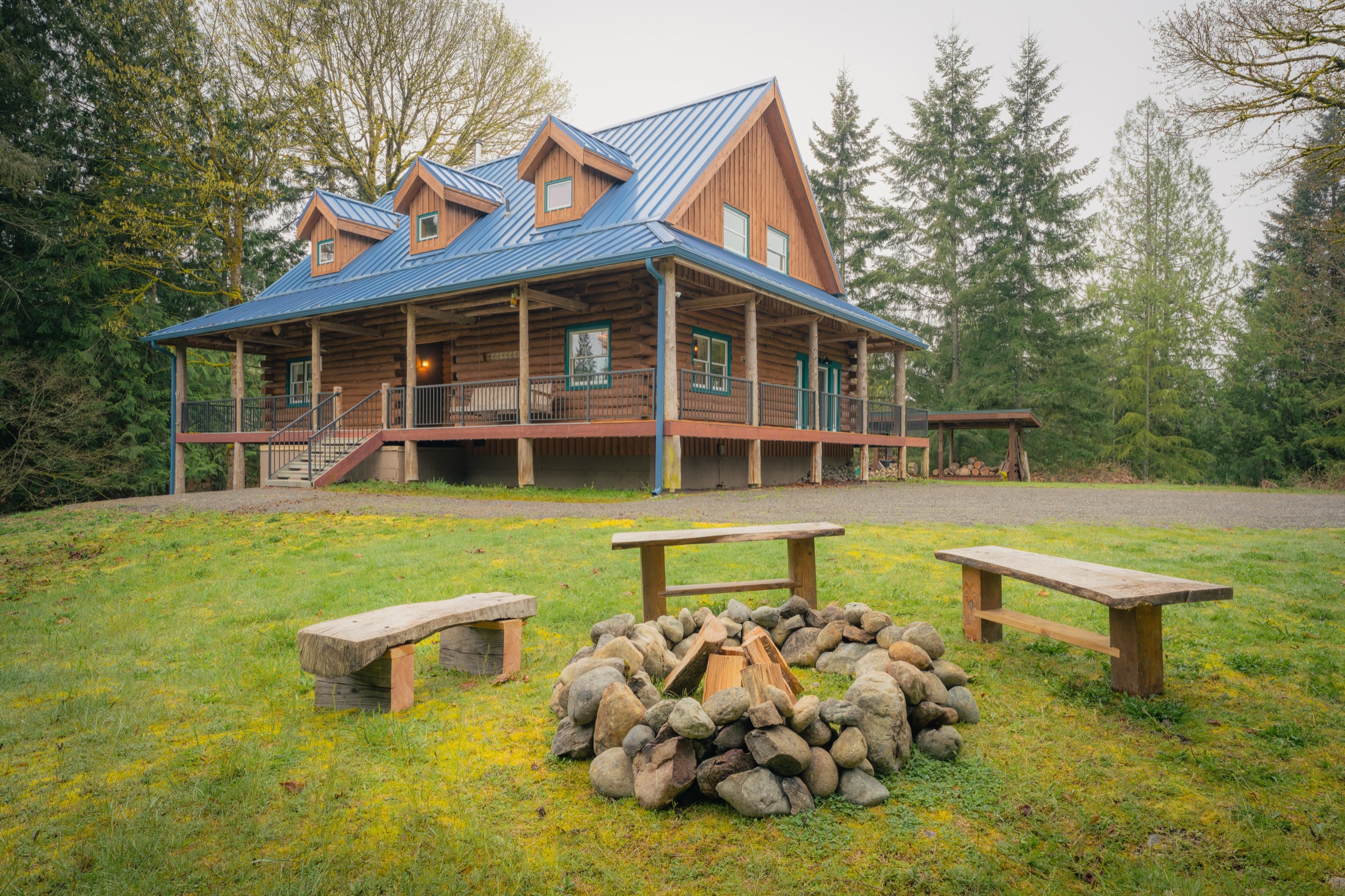 Blue Roof Lodge log home with blue standing-seam roof and outdoor fire pit