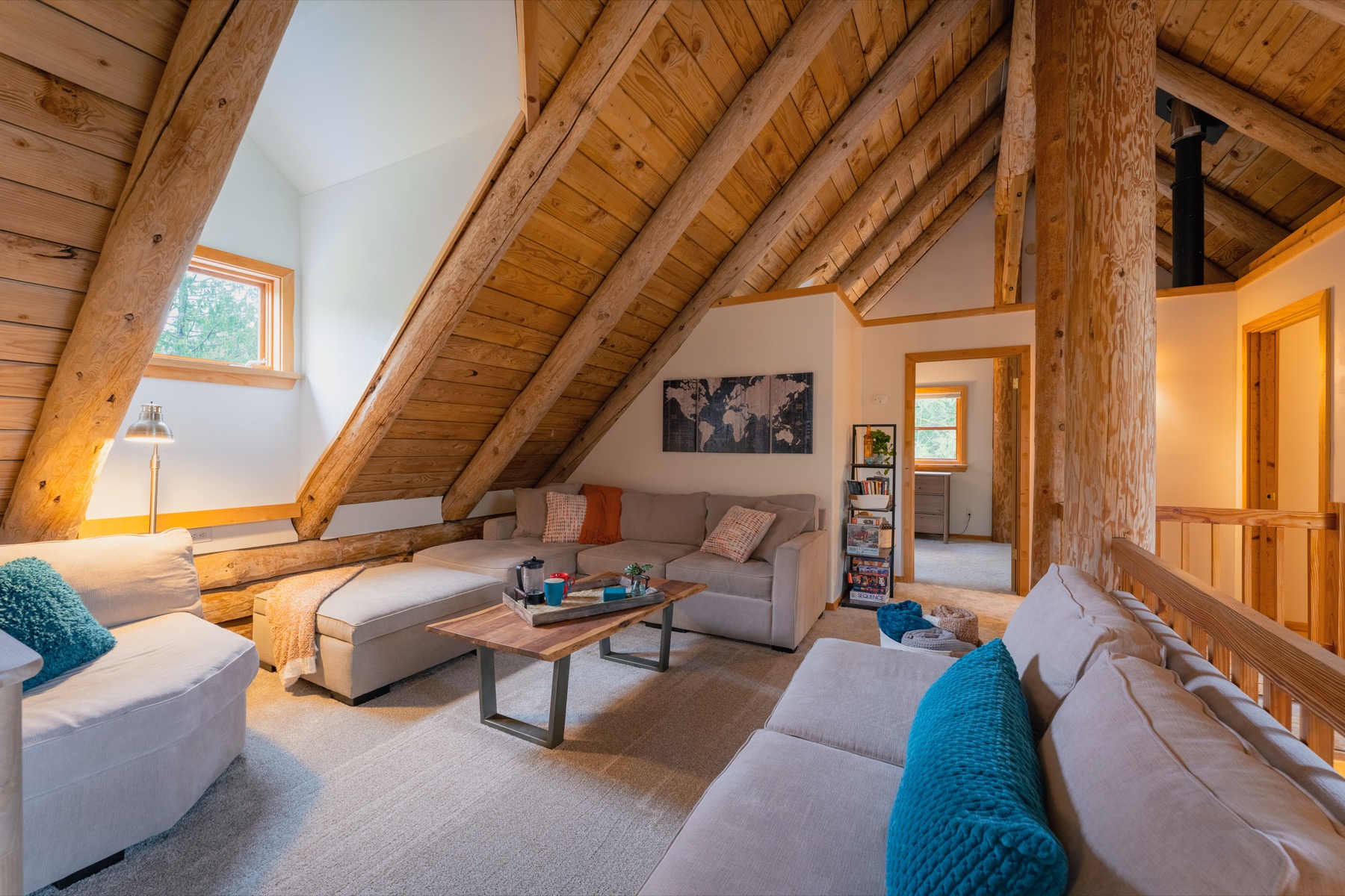 Upstairs loft living room with exposed beams and lounge seating